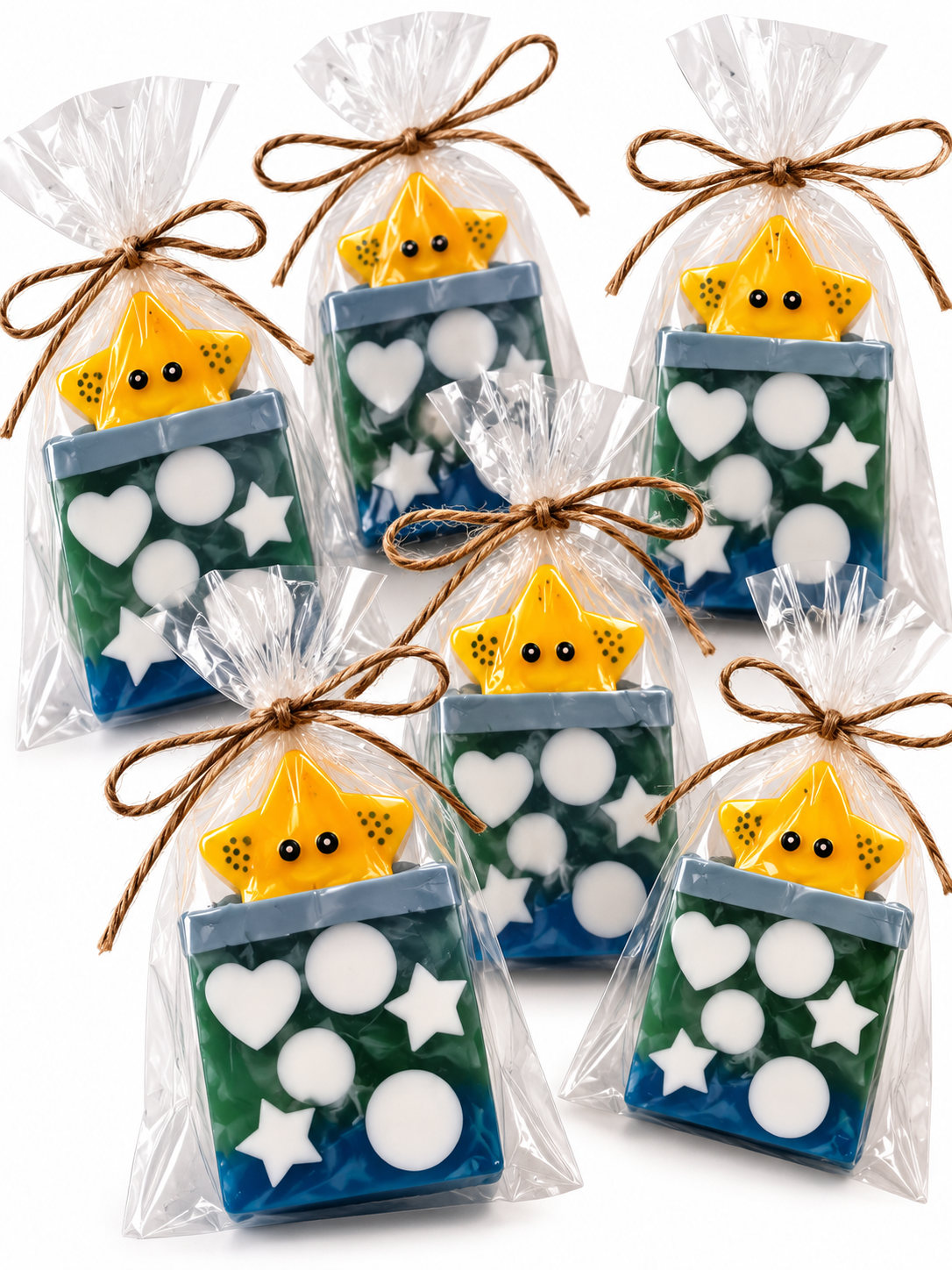 Cute star-shaped goat milk soap favors in clear cellophane bags tied with twine, each topped with a smiling yellow star